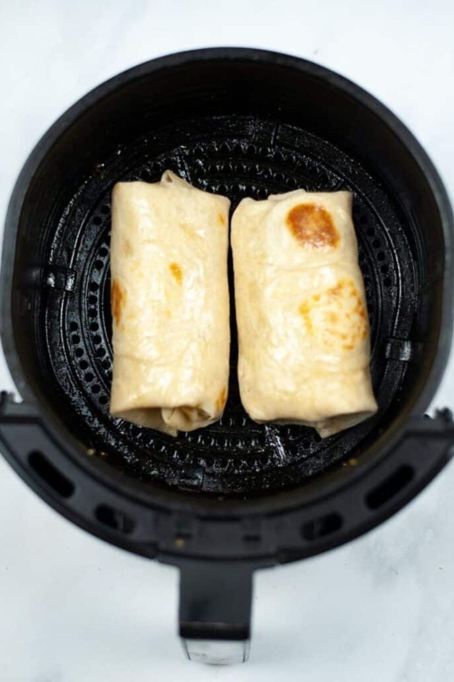 Air Fryer Breakfast Chimichangas in an air fryer basket on the table