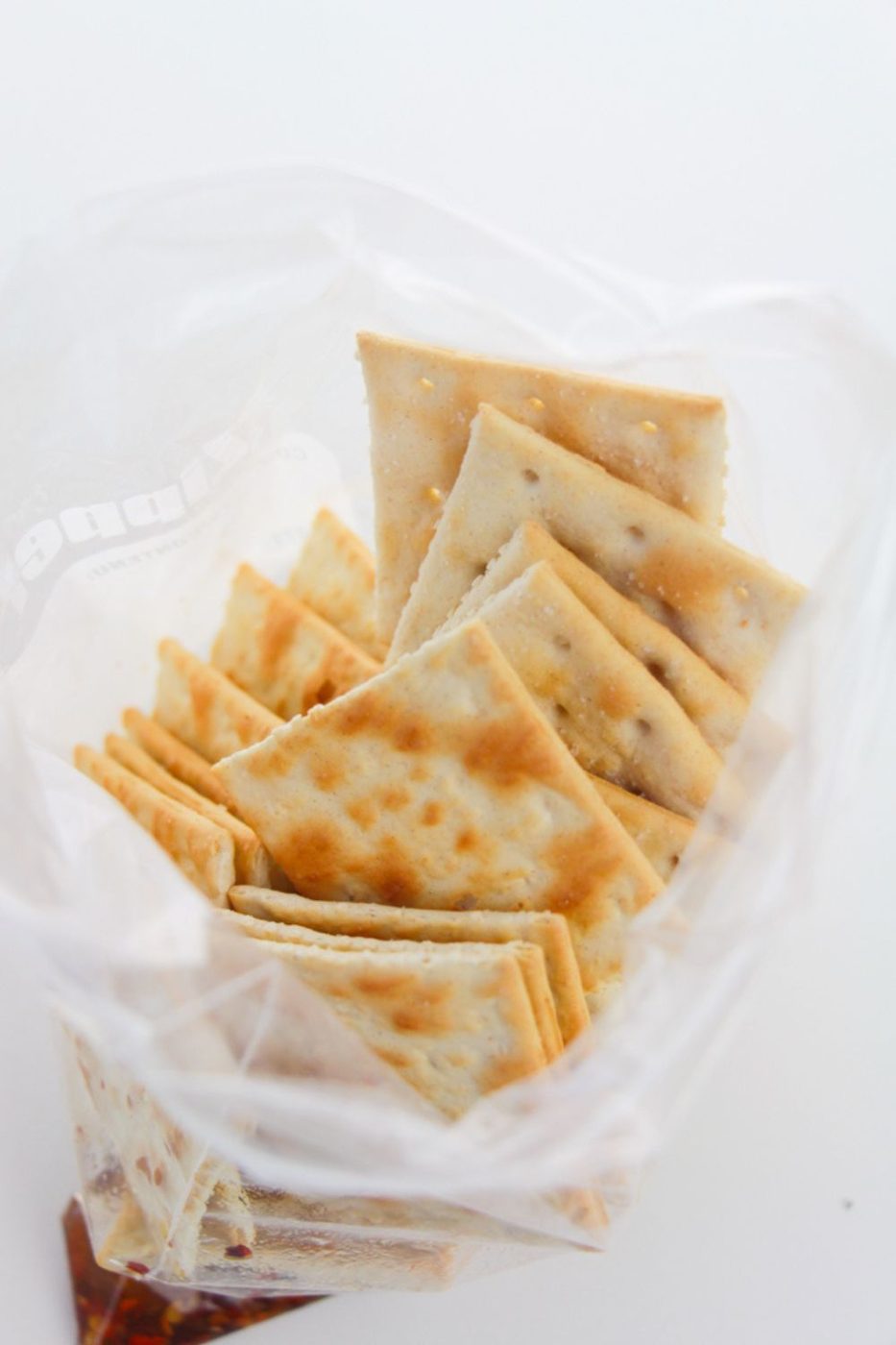 saltine crackers in a Ziploc bag on white table 