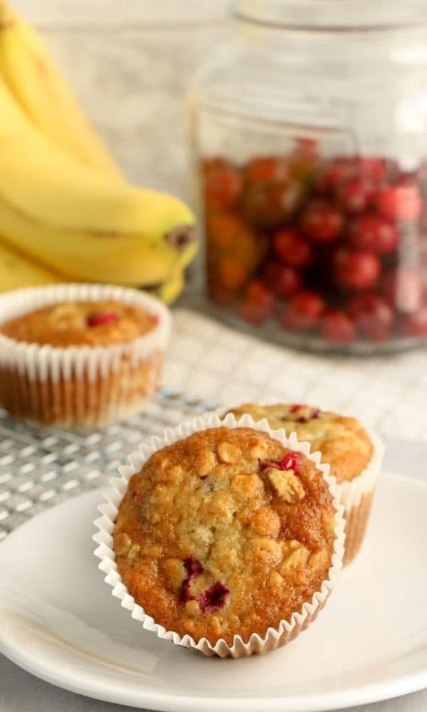 cranberry muffins on plate with bananas behind it