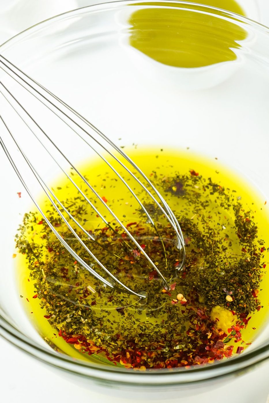 mixing olive oil and seasonings in a mixing bowl 