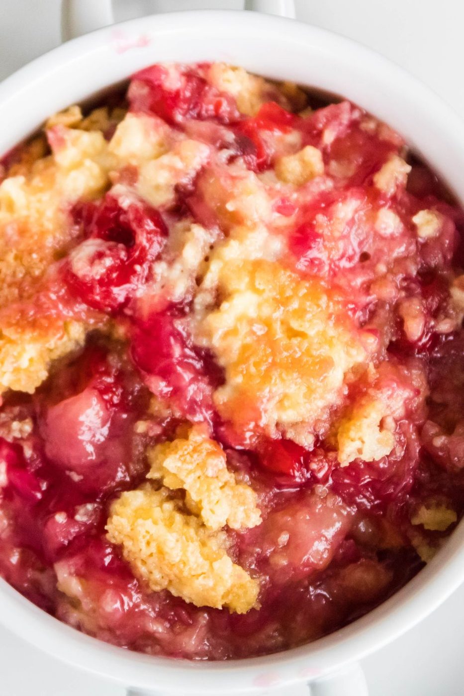 overhead view of dump cake in a white bowl 