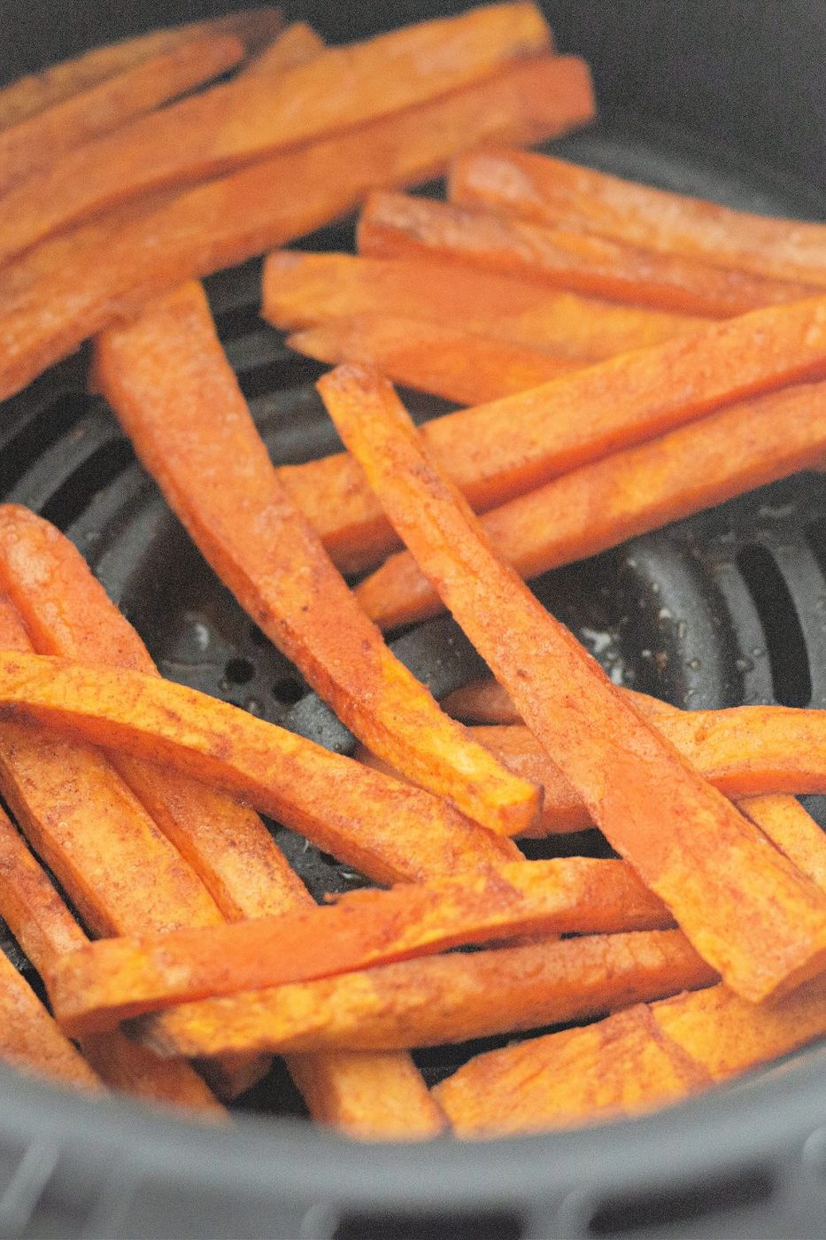 sweet potato fries in an air fryer basket 