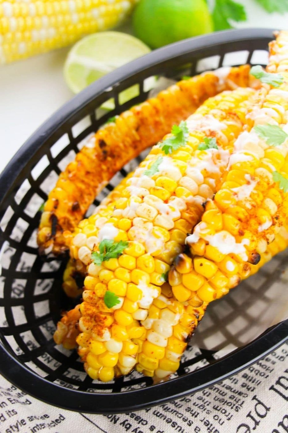basket with corn ribs with a cream sauce drizzled on top 
