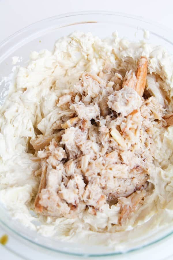 crab on top of a crab dip filling in glass bowl 