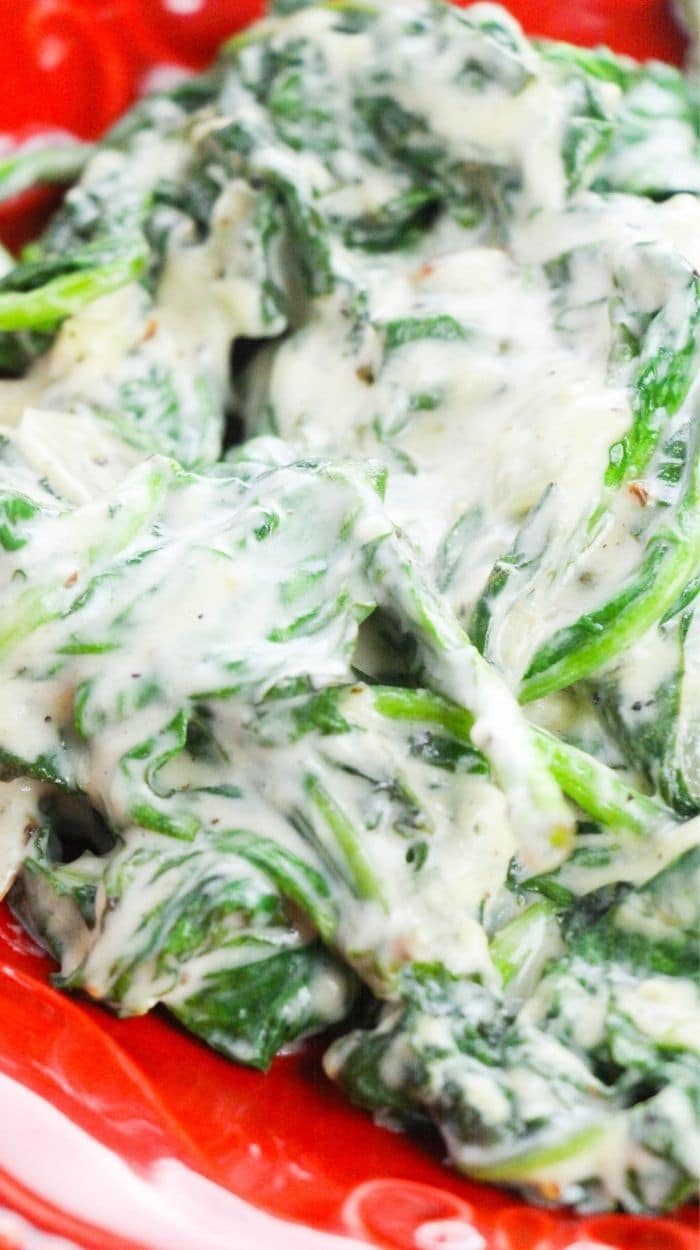 Serving creamed spinach on a red plate 