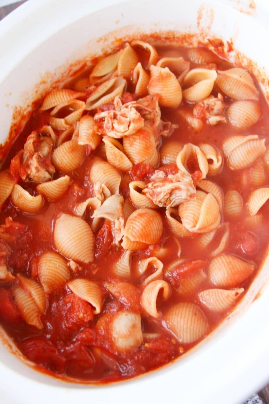 dry pasta in crockpot with tomato sauce and chicken