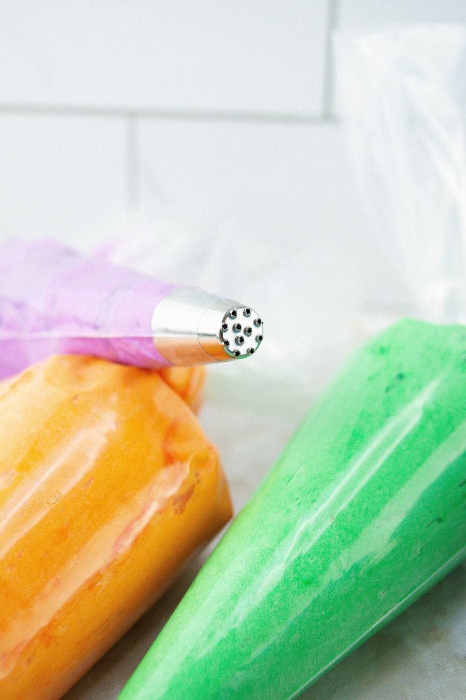 bright colored frosting in piping bags