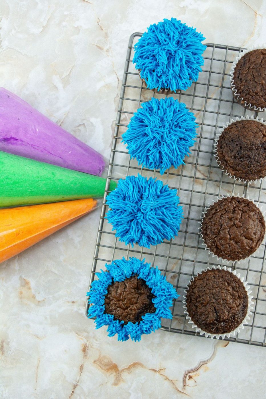 piping frosting on chocolate cupcakes