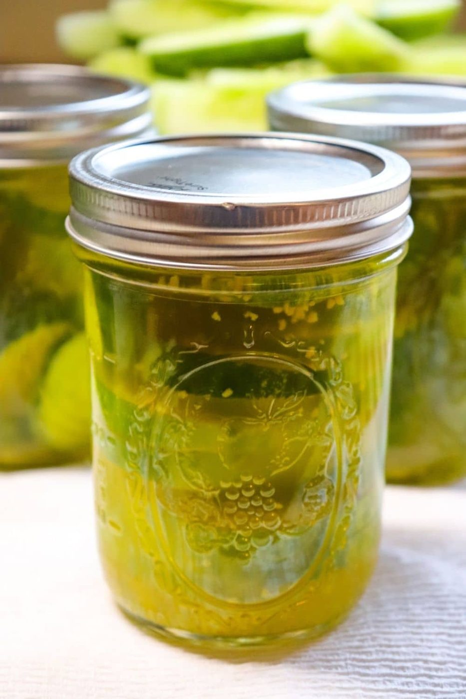 mason jars with pickles and brine in it 