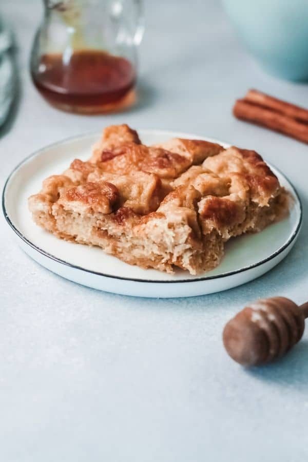 eggnog french toast bake on a plate with maple syrup behind it 