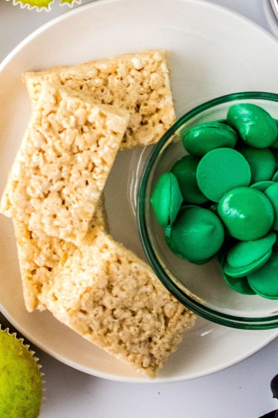 candy melts and rice krispies treats on white plate on counter 