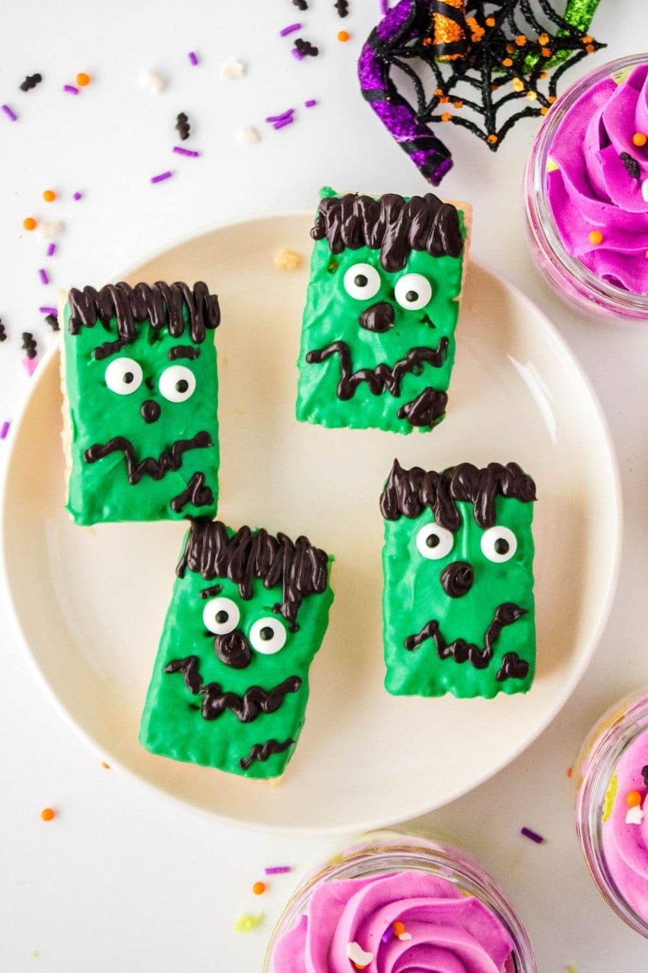 halloween rice crispy treats on a plate with cupcakes around it 