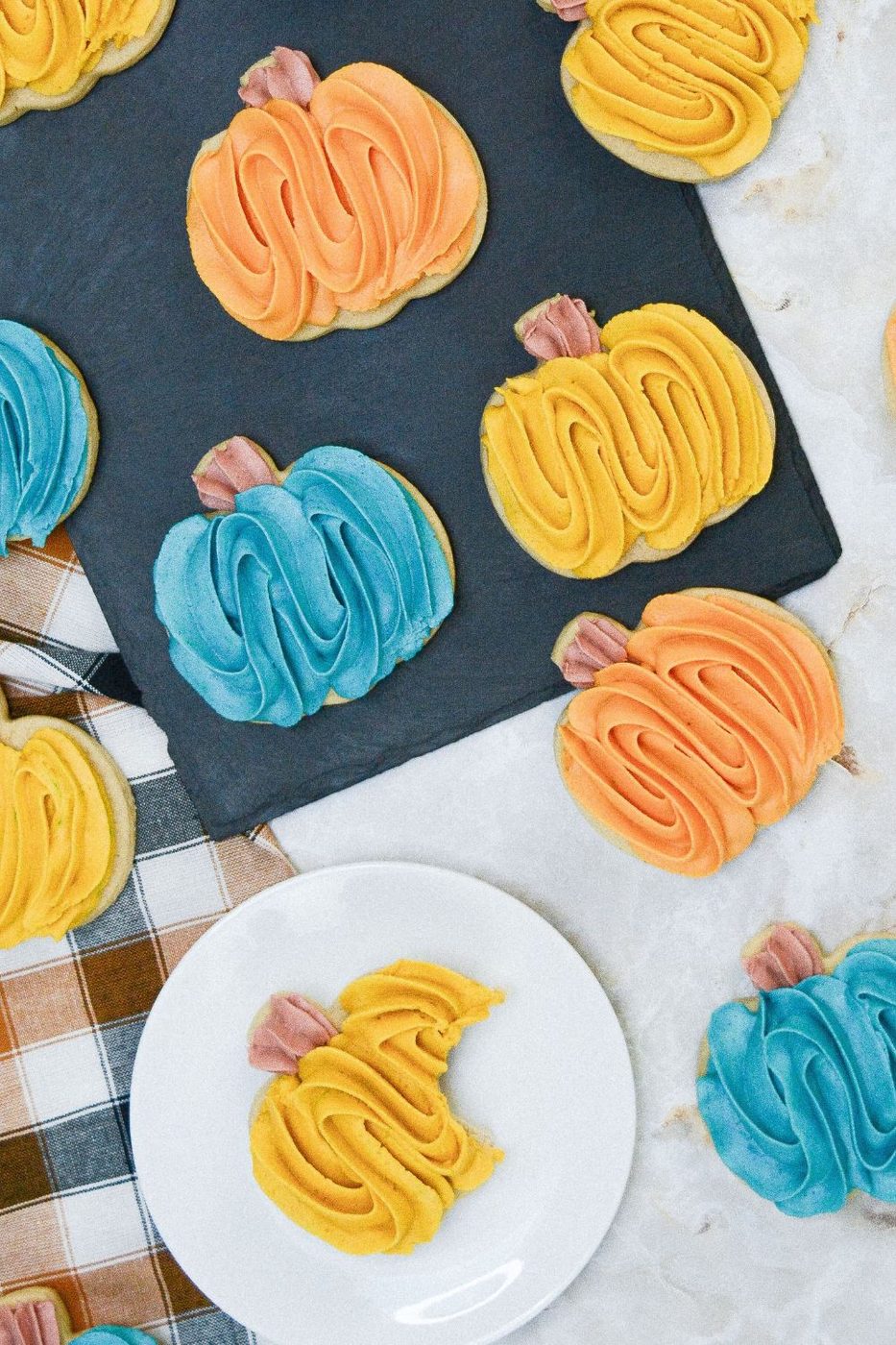 cookies on table with one on a plate and bite taken out of it