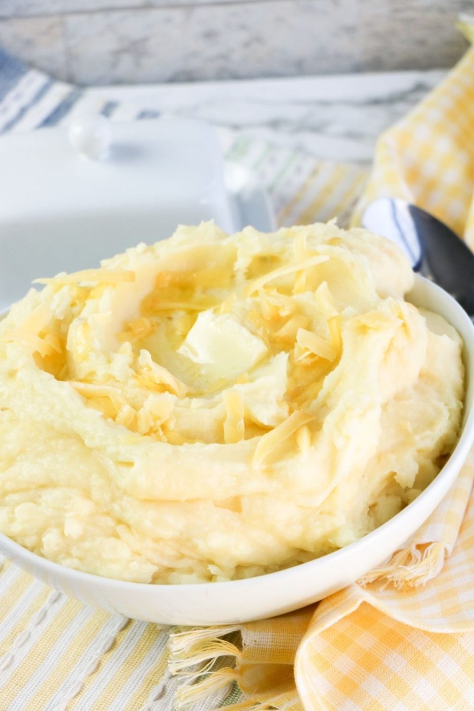 potatoes in a bowl on white counter with yellow towel by it 