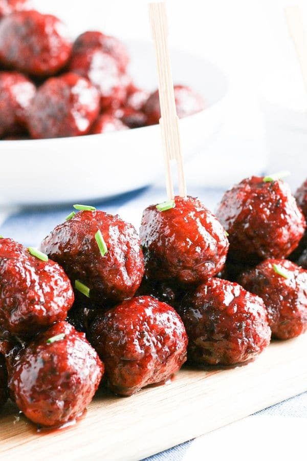 side view of meatballs with garnish on top stacked on tray 