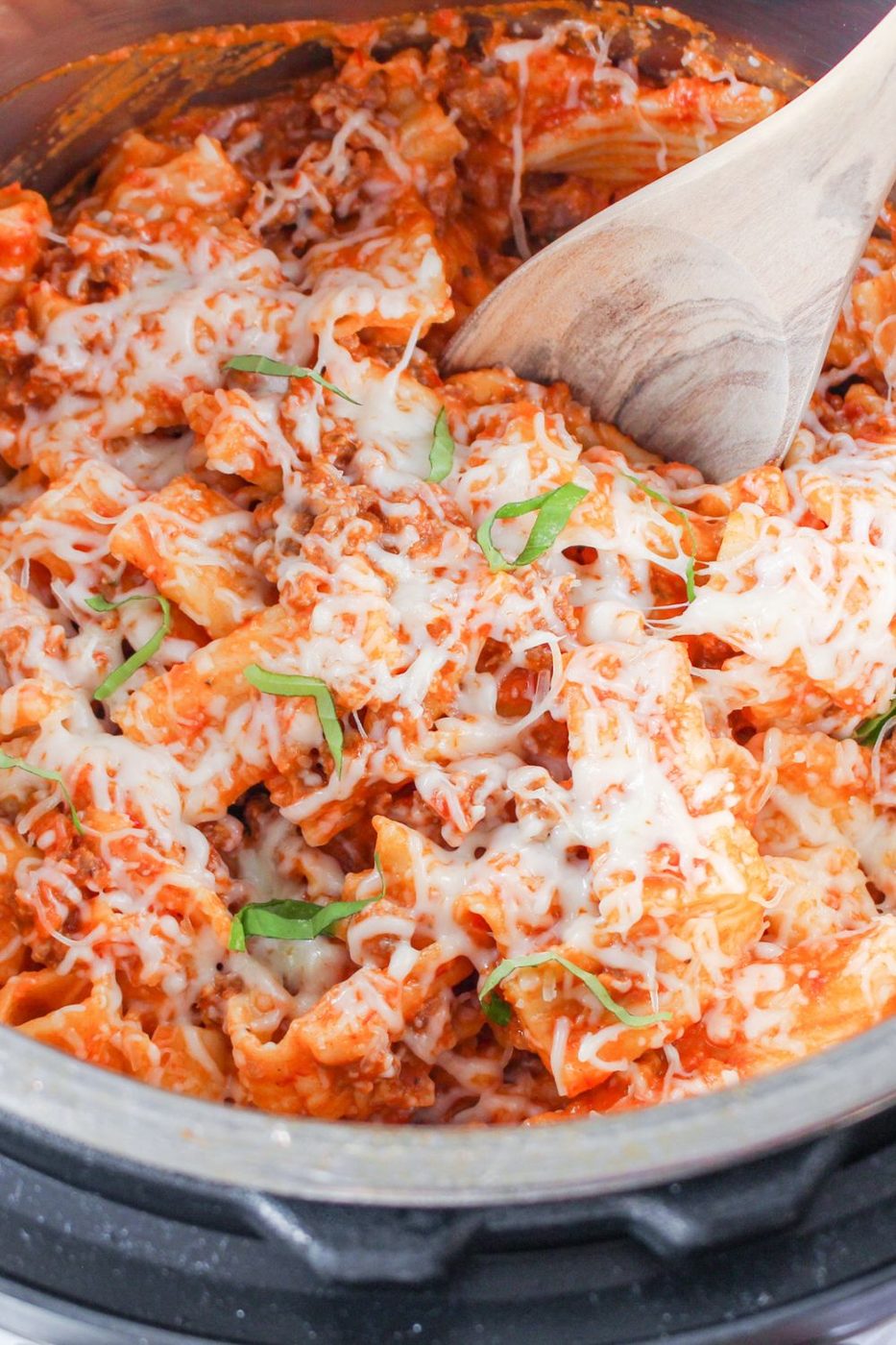rigatoni in pressure cooker with wooden spoon in it 