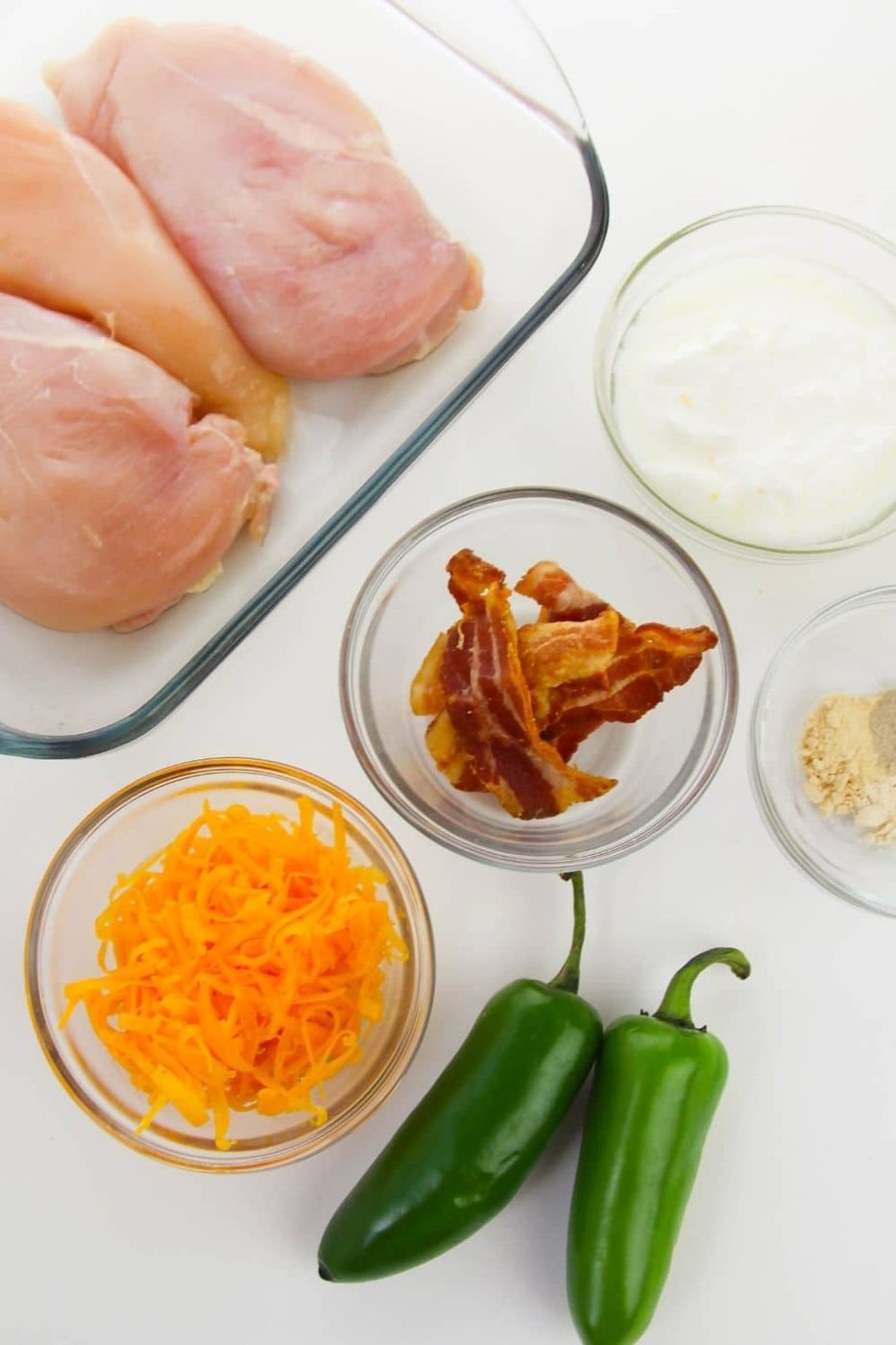 ingredients for loaded chicken in glass bowls and containers on counter
