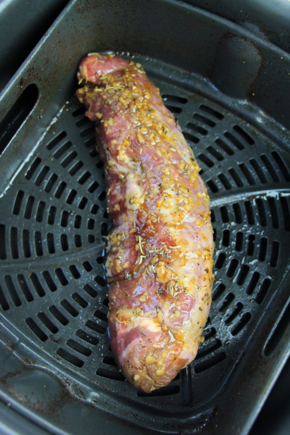 raw Marinated Pork Tenderloin in an air fryer basket