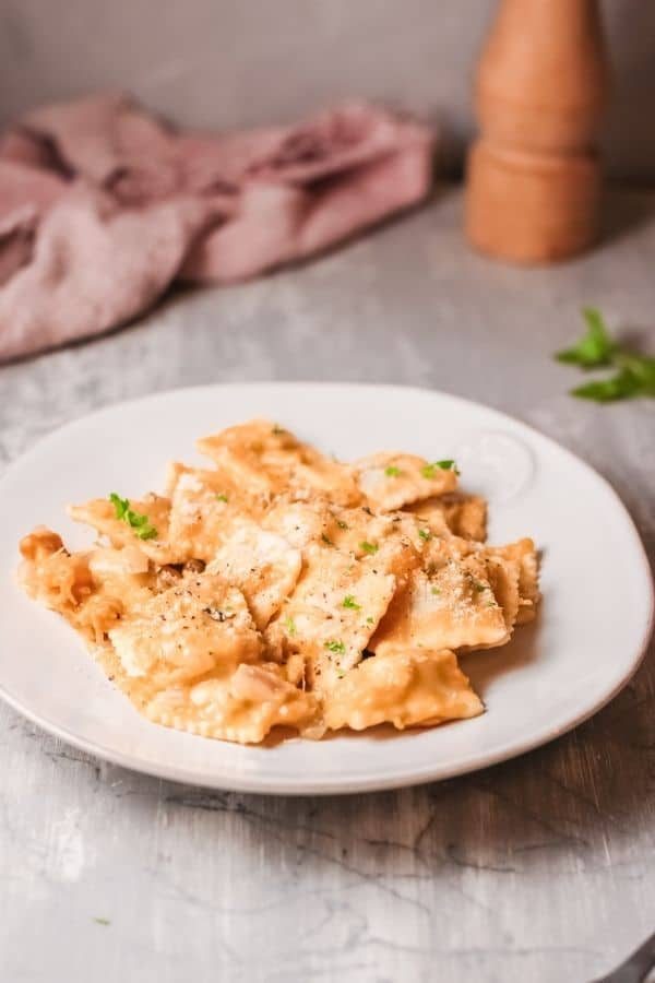 plate of pasta with pepper and towel behind on table 
