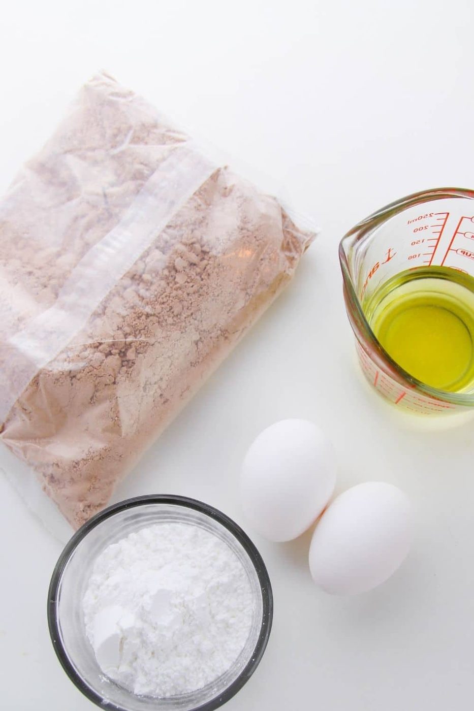 box cake mix, egg, oil, and powdered sugar on counter 