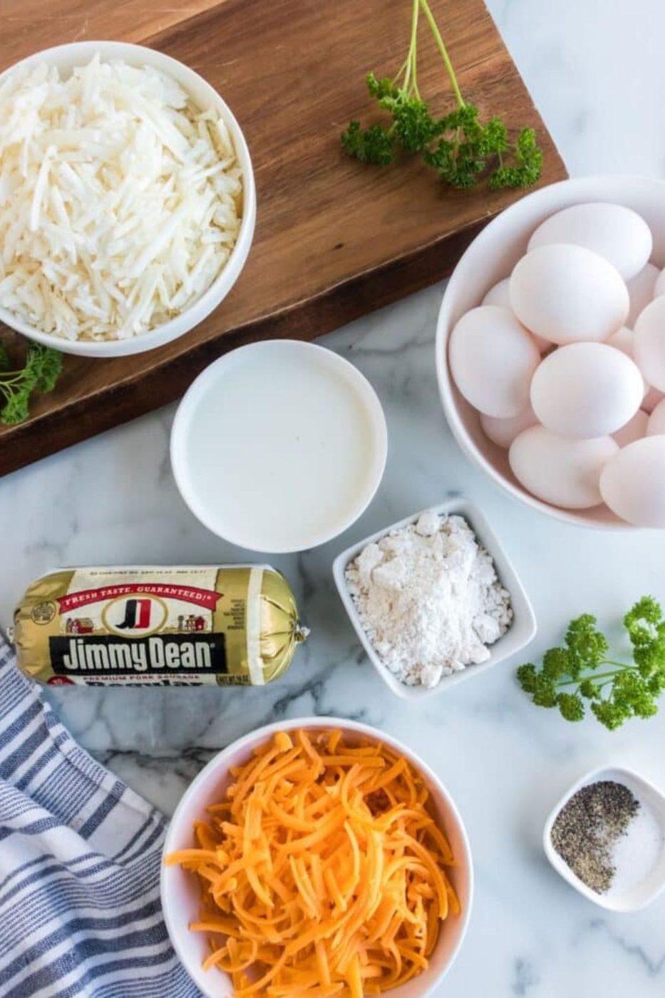 ingredients to make the sausage and egg casserole in bowls on table in single serve containers 