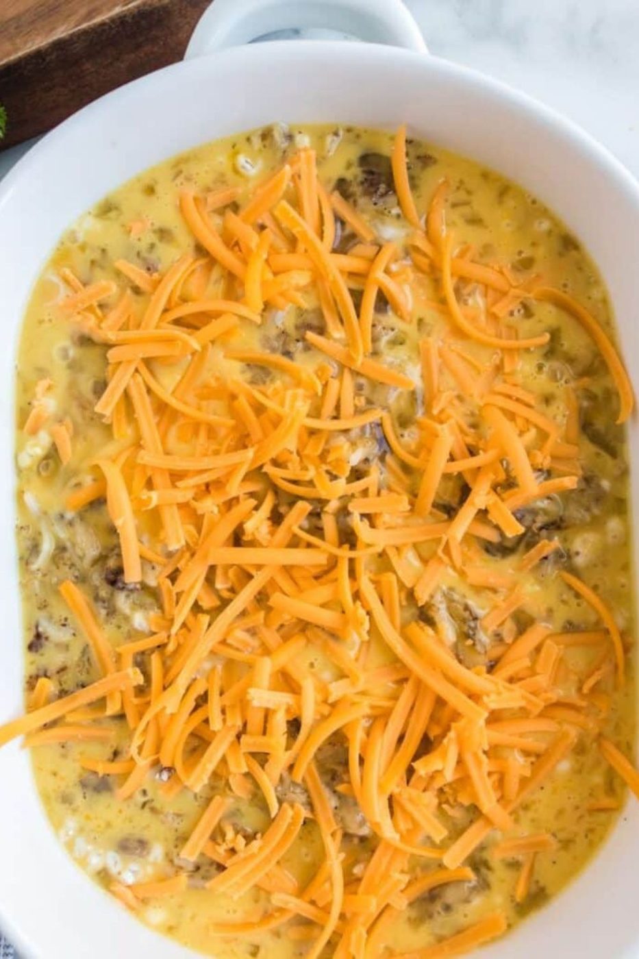 Sausage and Egg Casserole in a pan with shredded cheese 