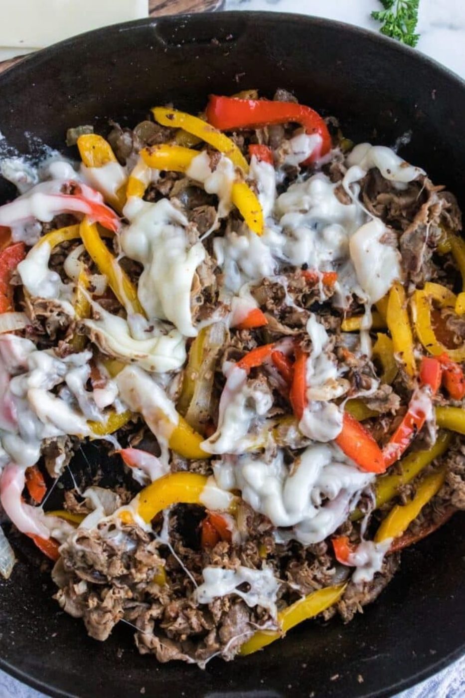 Skillet Shaved Steak Sandwich and cheese mixture in a cast iron skillet