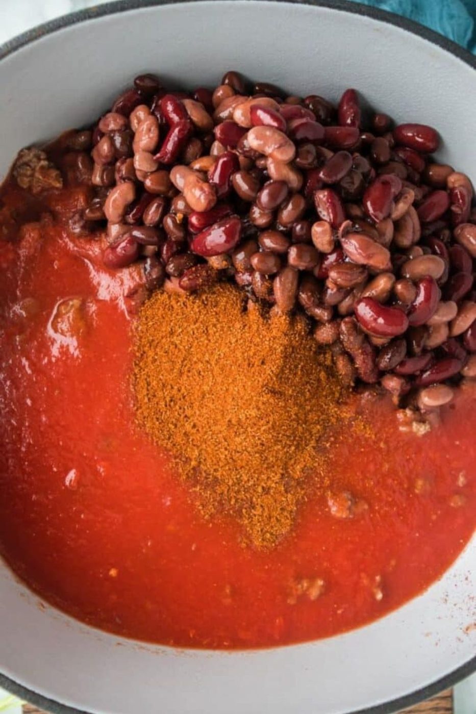 chili in a dutch oven with beans, tomato sauce, and chili