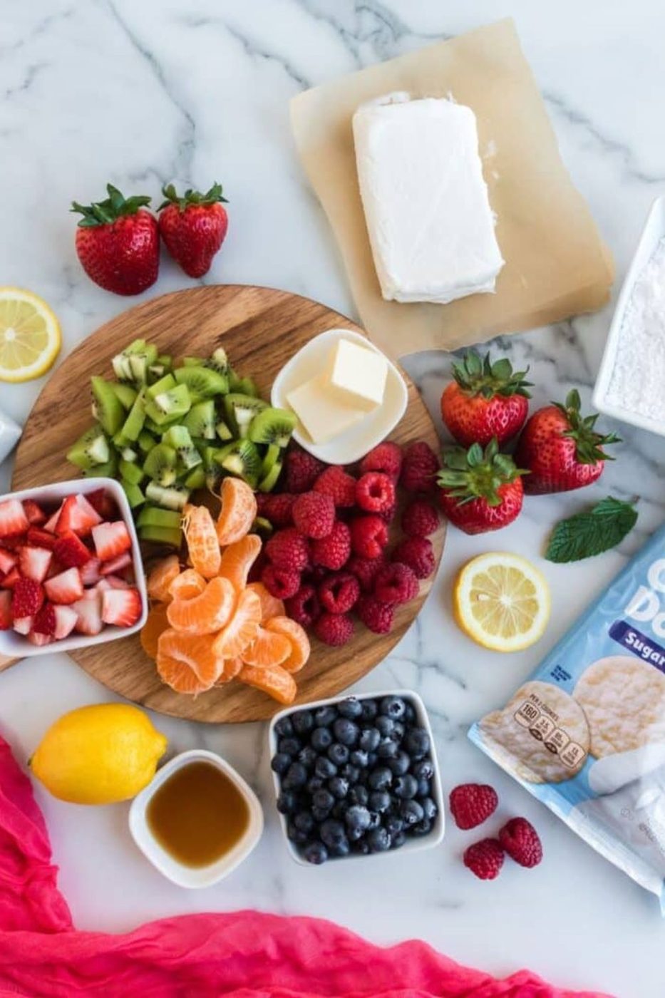 ingredients for Mini Fruit Pizza With Sugar Cookie Crust scattered on table 