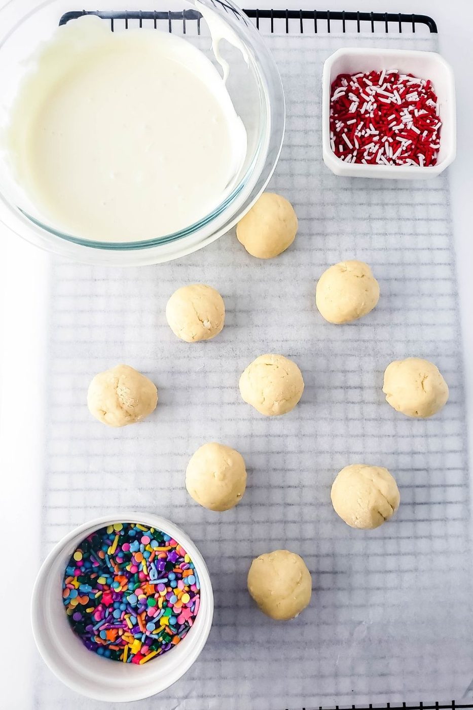sugar cookie truffles on lined cooling rack with chocolate in a bowl