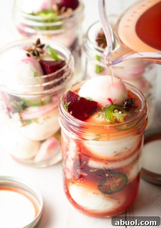 The process of pickling: a jar being filled with vibrant beet pickling liquid, showcasing the beautiful reddish hue that will infuse the eggs.