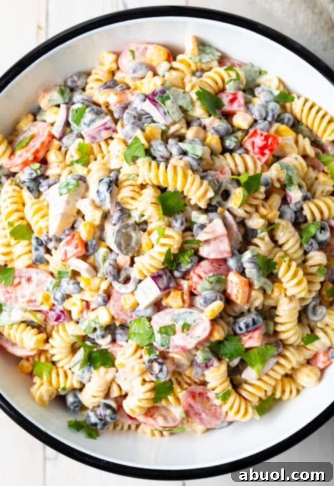 A top down shot of Creamy Southwest Pasta Salad in a white serving bowl, showcasing vibrant colors and textures.