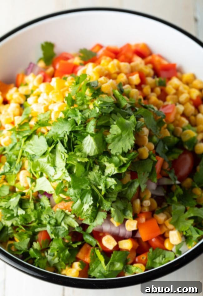 Bowl with fresh ingredients for pasta salad, including black beans and corn.