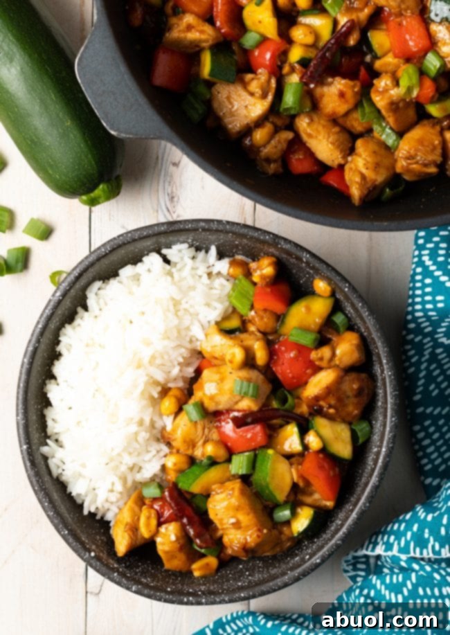 A vibrant top-down view of the best homemade Kung Pao Chicken, showcasing perfectly cooked chicken, crisp vegetables, and a glossy, spicy sauce, inviting you to dive in.