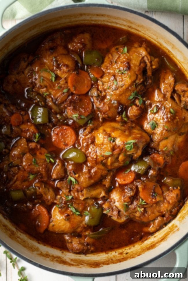 A rich and saucy brown chicken stew recipe with tender chicken pieces, carrots, and bell peppers in a bowl, ready to serve.