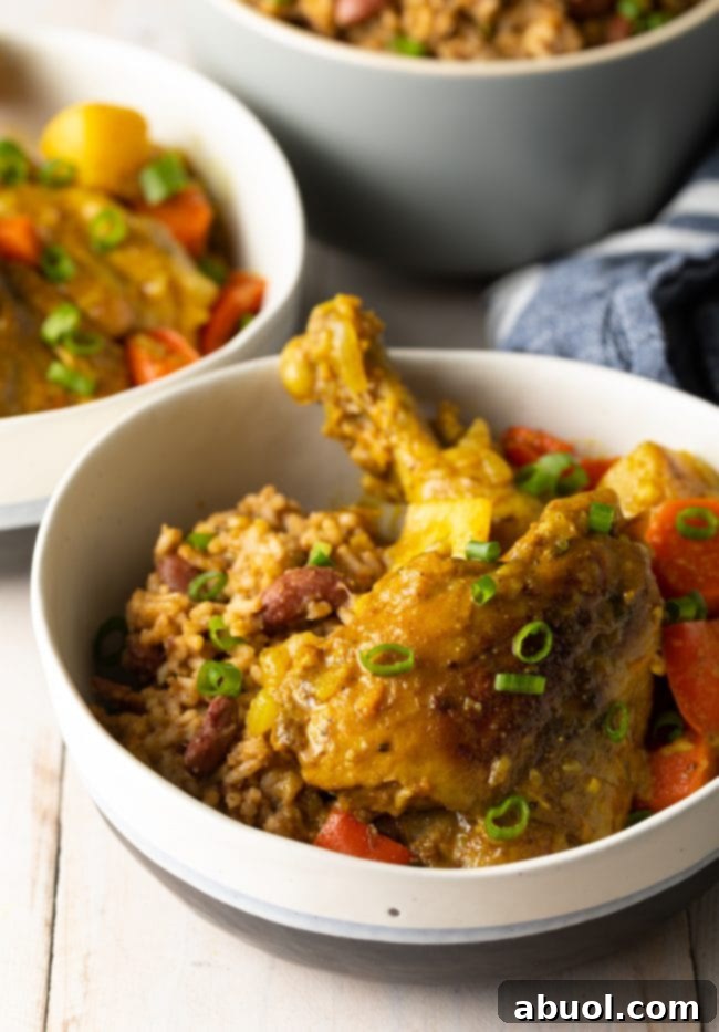 A bowl of authentic Jamaican curry chicken, rich yellow in color, served with fluffy white rice