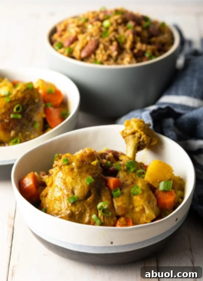 A serving of Jamaican Curry Chicken, perfectly cooked, in a bowl with a fork, ready to be enjoyed