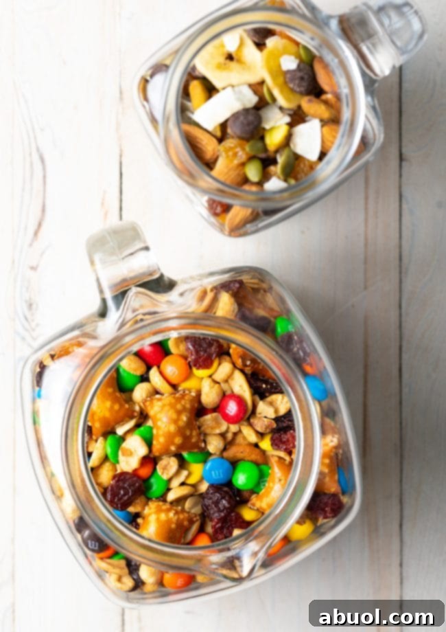Overhead view of homemade trail mix displayed beautifully in multiple glass jars, perfect for gifting or sharing.