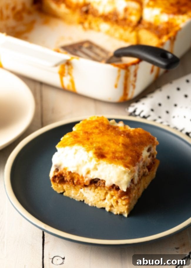 Square of homemade pastitsio on a gray plate.