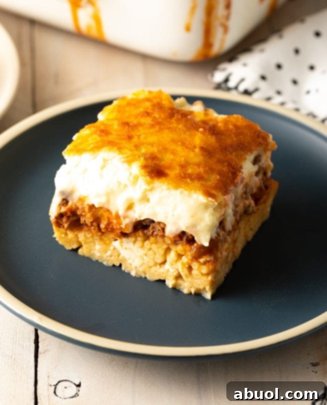Square of homemade pastitsio on a gray plate.