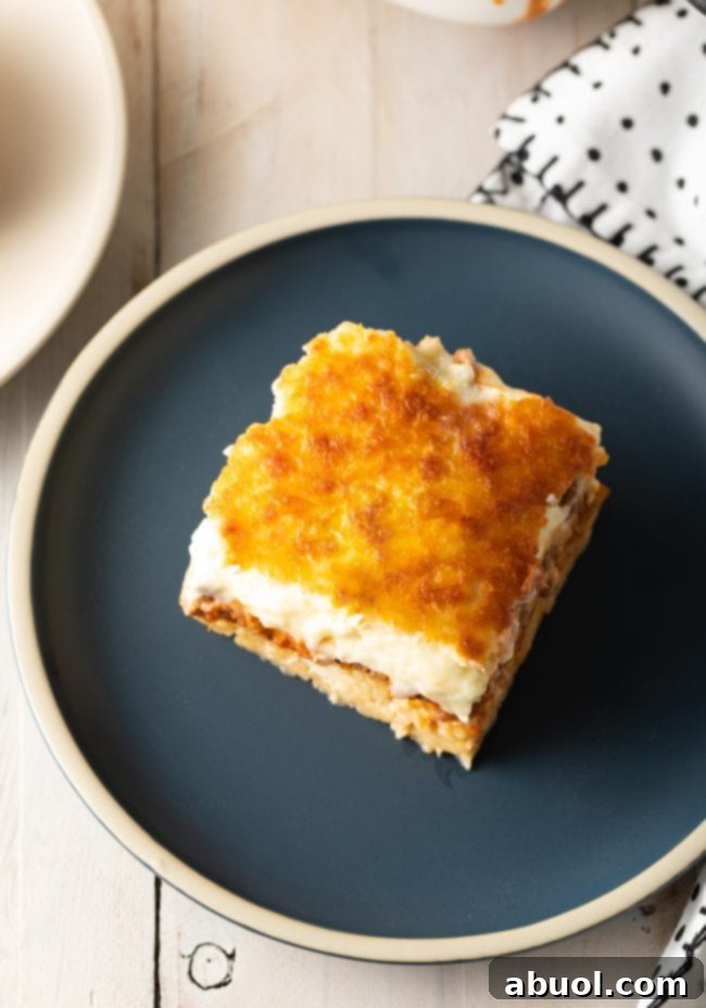 Top down view square of pastitsio on a gray plate.