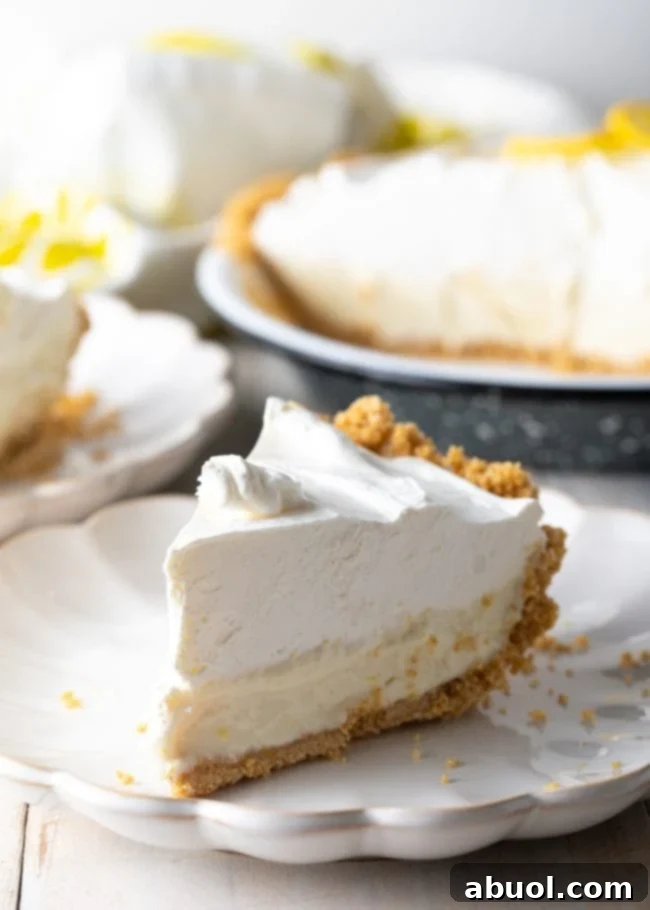 slice of lemon icebox pie on a plate with pie in the background