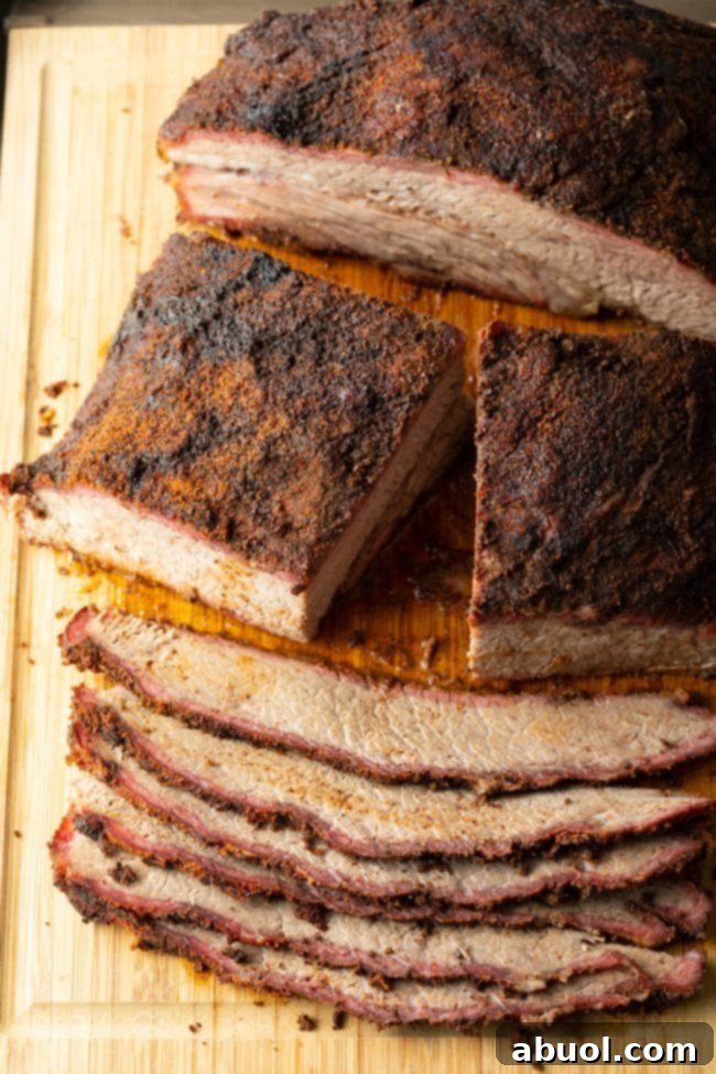 Dry-Brined Smoked Brisket 12 Slices of beef brisket being expertly carved after resting, showcasing its tender texture and juicy interior.