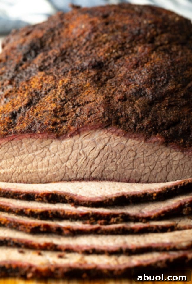 Dry-Brined Smoked Brisket 13 An inviting close-up of thinly sliced Texas smoked beef brisket, perfectly arranged to show its deep smoke ring and juicy texture.