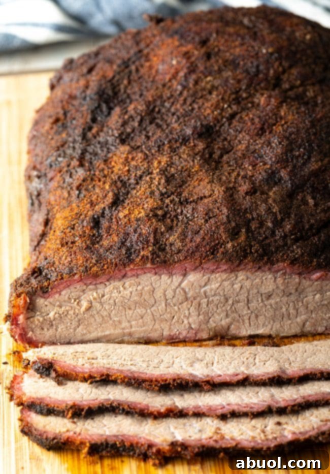 Dry-Brined Smoked Brisket 14 An overhead view of numerous slices of juicy beef brisket arranged neatly on a wooden cutting board, ready to be served.