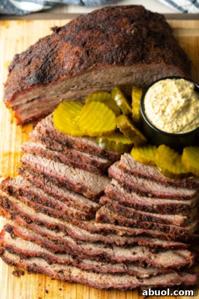 Dry-Brined Smoked Brisket 15 Perfectly smoked brisket, sliced and arranged on a wooden board, served with an inviting display of pickles and spicy mustard.