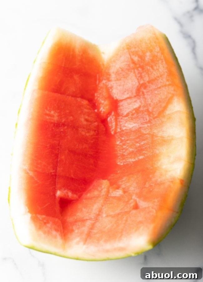 A close-up shot of a freshly cut watermelon rind, showing a thin layer of pink flesh still attached.