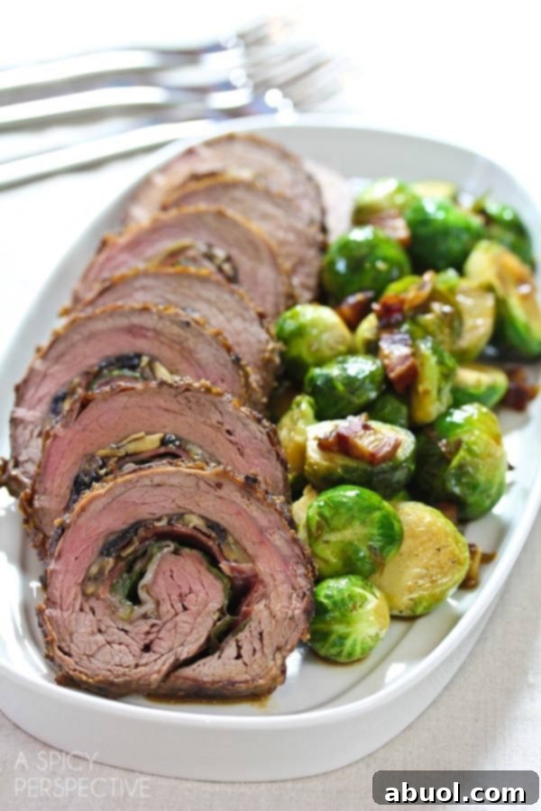Stuffed flank steak pinwheels beautifully arranged on a platter with roasted brussel sprouts, ready to serve.