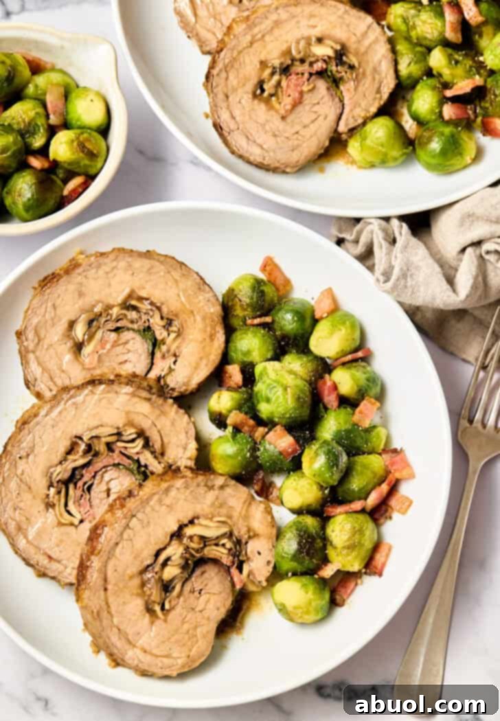 Overhead shot of Stuffed Beef Flank Steak with Cheese, Mushrooms, and Prosciutto, served with roasted brussels sprouts.
