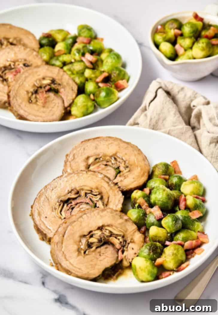 Another perspective of the Stuffed Beef Flank Steak with Cheese, Mushrooms, and Prosciutto overhead shot on plate with brussels sprouts.